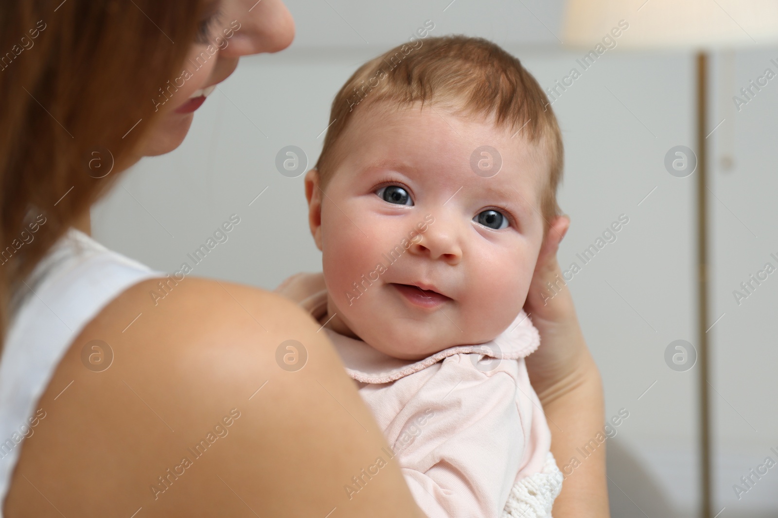 Photo of Young woman with her little baby resting after breast feeding at home, closeup