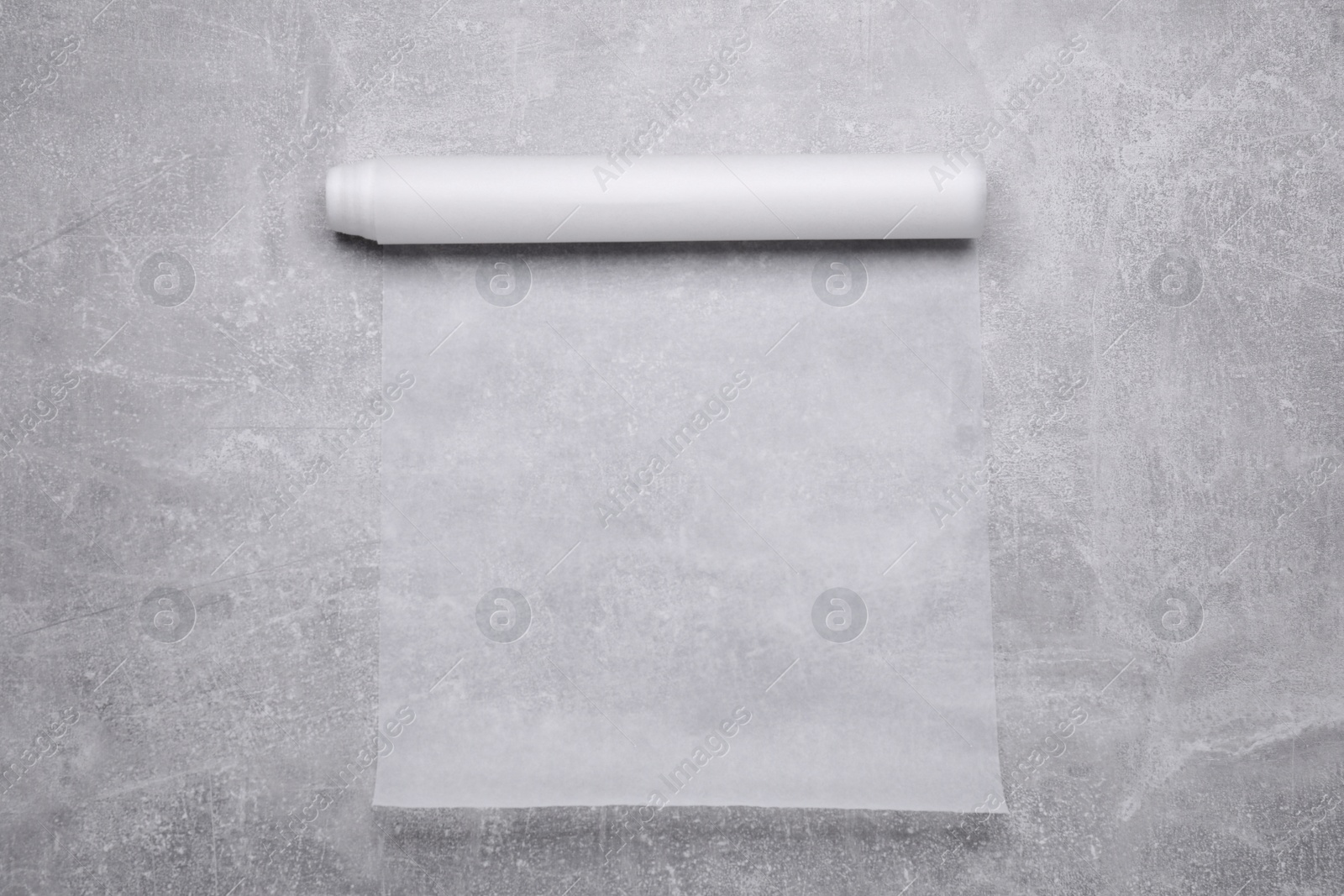 Photo of Roll of baking paper on light grey table, top view