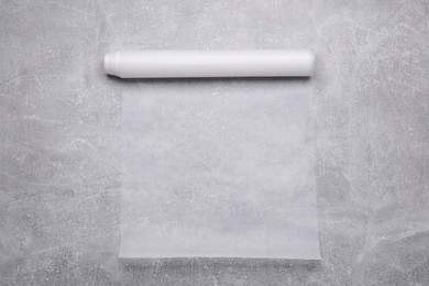 Roll of baking paper on light grey table, top view