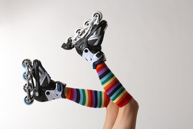 Photo of Woman with roller skates on white background, closeup