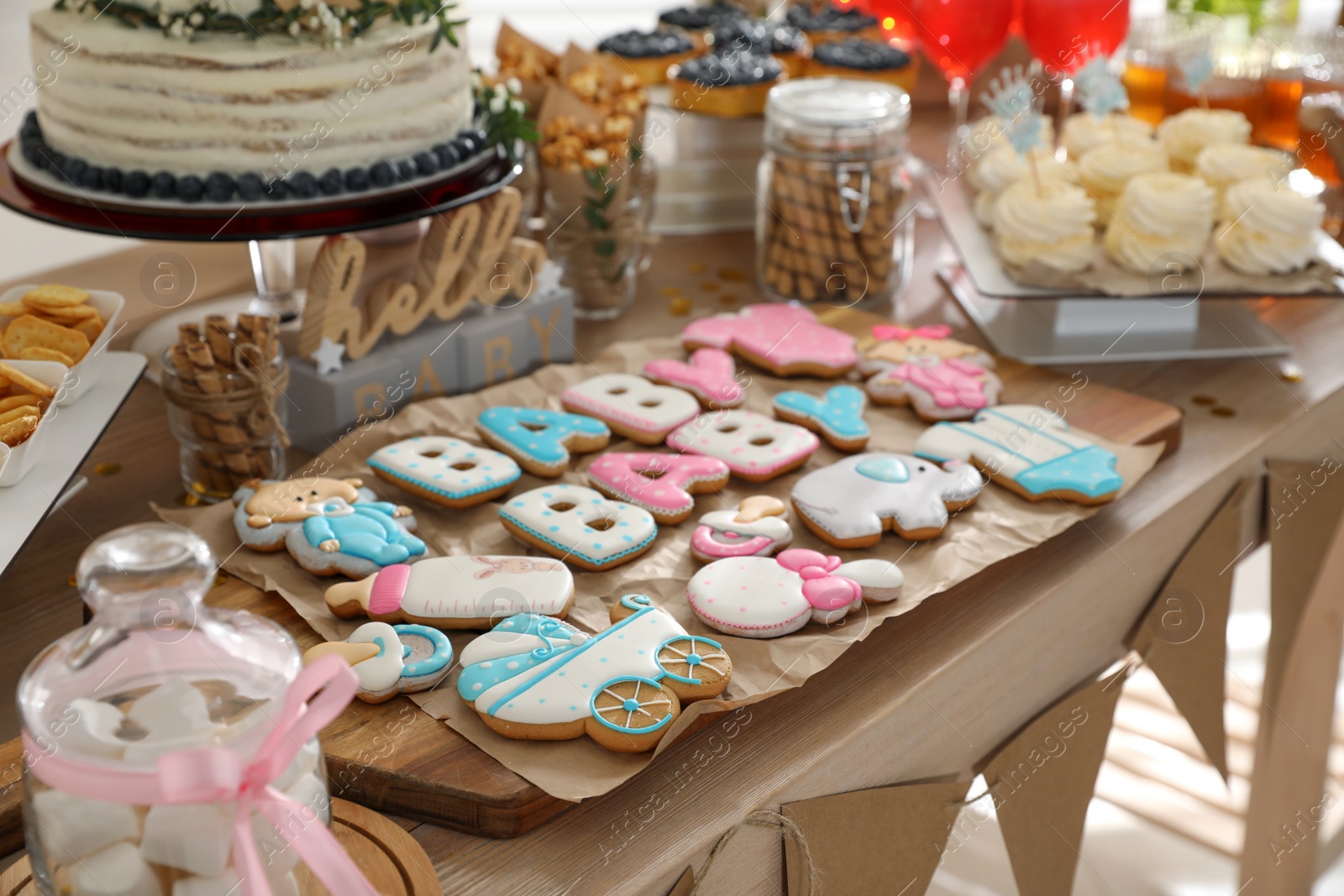 Photo of Baby shower party. Delicious cookies on wooden table indoors