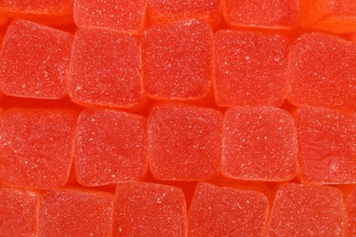 Photo of Tasty orange jelly candies as background, closeup