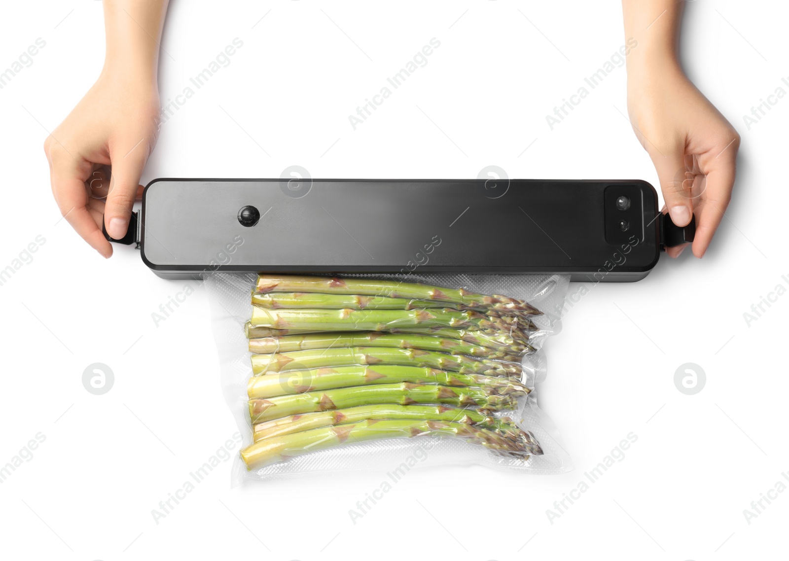 Photo of Woman using for vacuum packing with plastic bag of asparagus on white background, top view