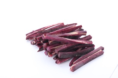 Raw purple carrot sticks isolated on white