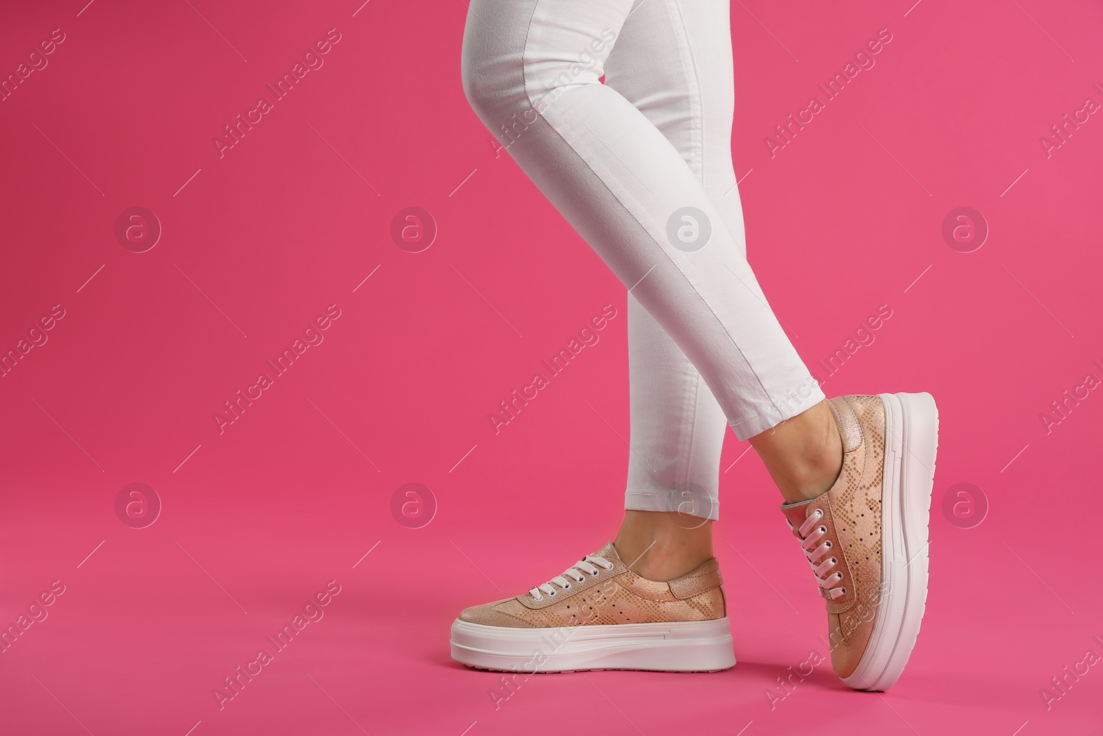 Photo of Woman wearing shoes on pink background, closeup. Space for text