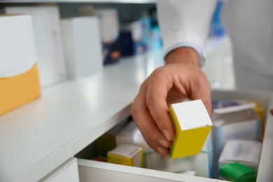 Photo of Professional pharmacist with medicine in drugstore, closeup