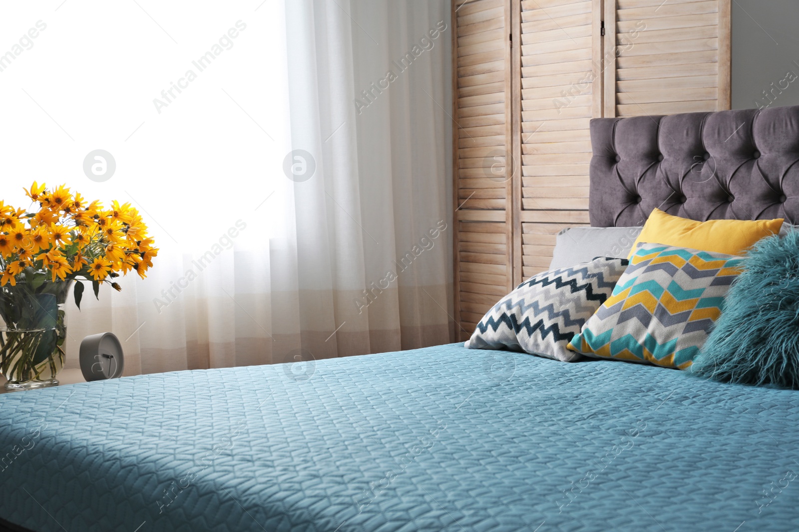 Photo of Different pillows on bed in room. Idea for interior decor