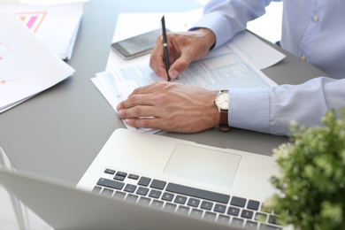 Photo of Tax accountant working with documents at table