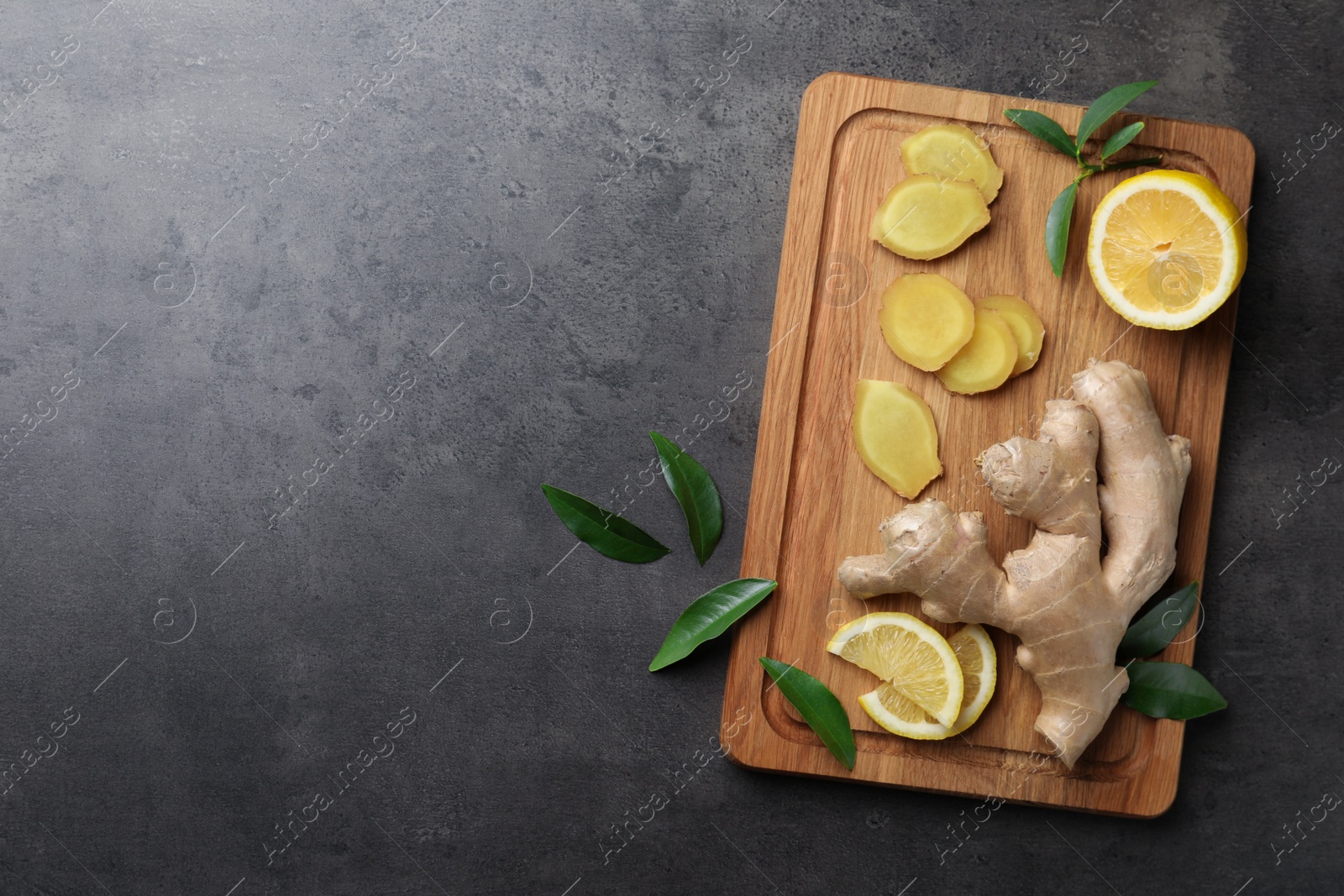 Photo of Fresh lemon and ginger on grey table, top view. Space for text