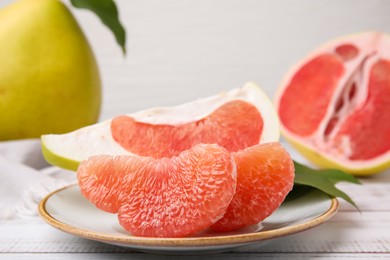 Tasty pomelo fruits on white wooden table, closeup