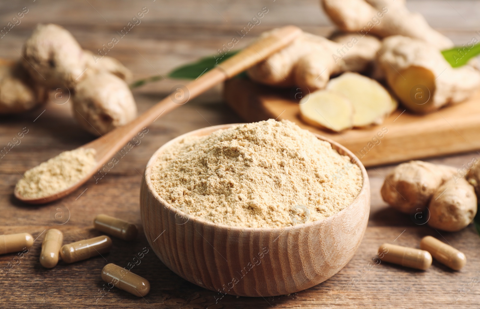 Photo of Dry, fresh and capsuled ginger on wooden table