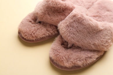 Photo of Pair of stylish soft slippers on beige background, closeup