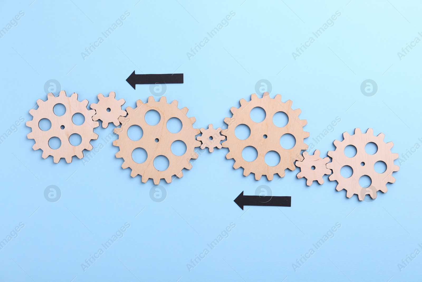 Photo of Business process organization and optimization. Scheme with wooden figures and arrows on light blue background, top view