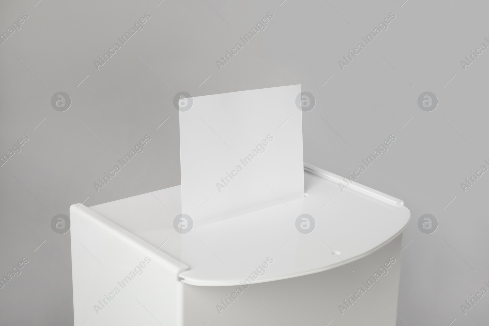 Photo of Ballot box with vote on light grey background, closeup. Election time