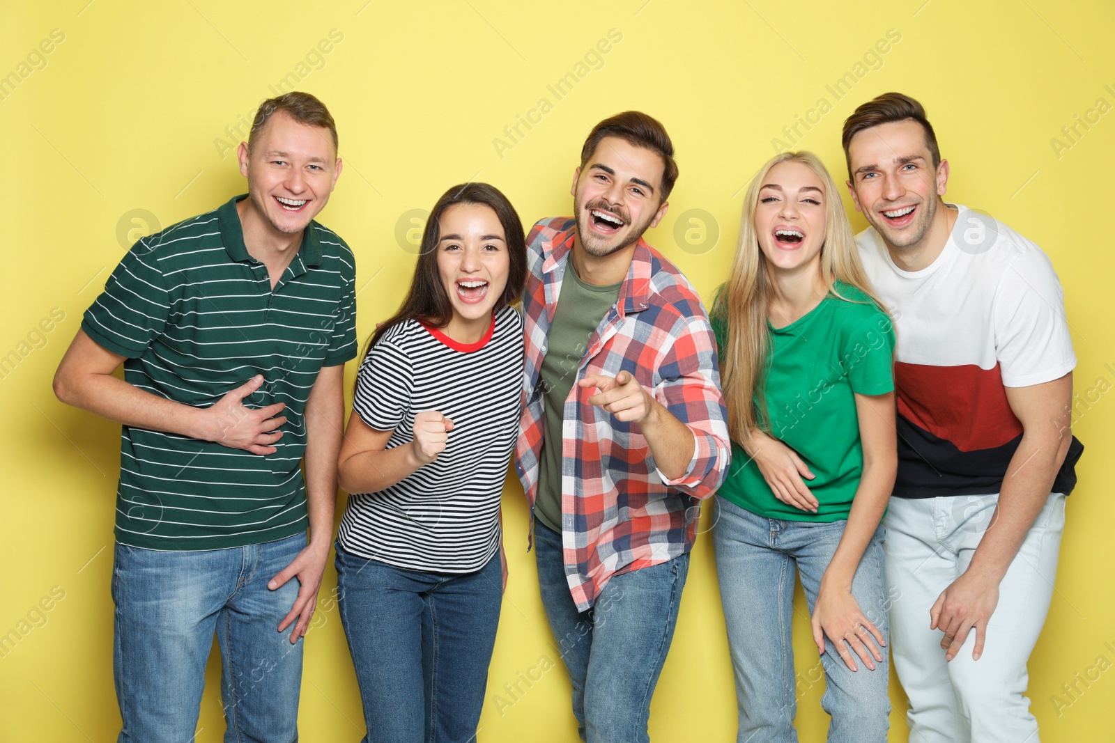 Photo of Group of friends laughing together against color background