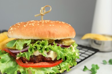 Photo of Delicious burger with beef patty and lettuce on white table, closeup. Space for text