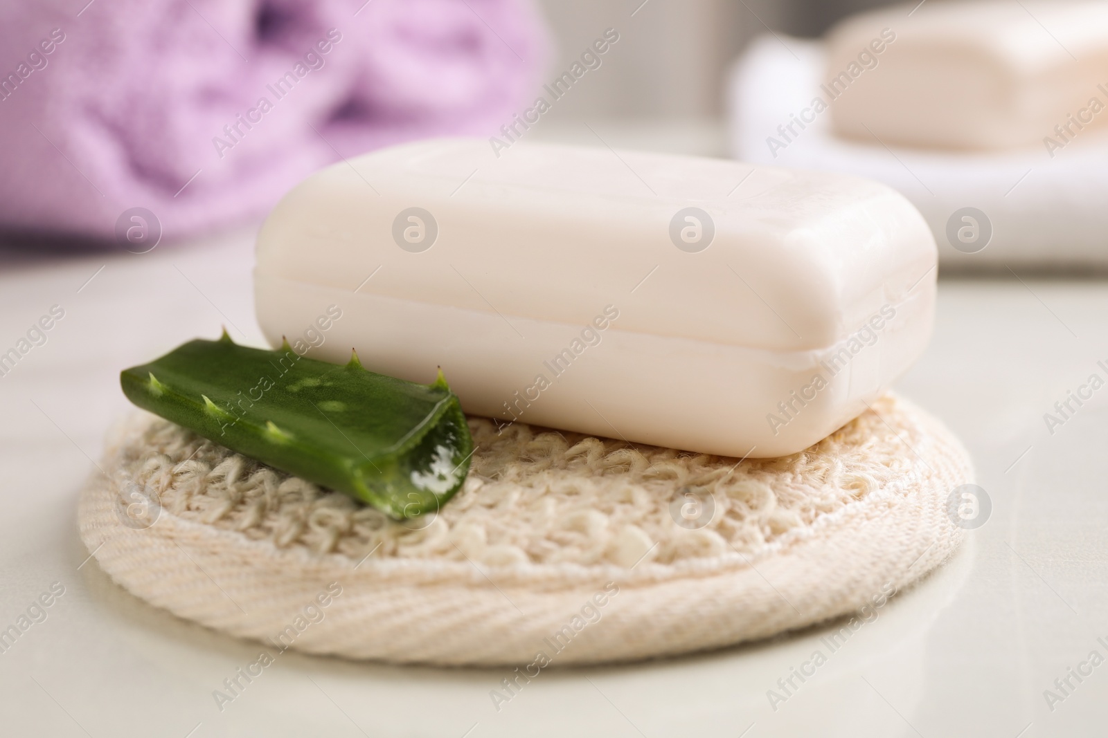 Photo of Soap bar, aloe vera and cloth on white table