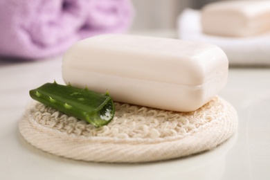 Soap bar, aloe vera and cloth on white table