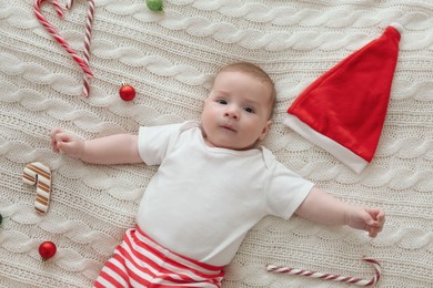 Photo of Cute little baby and Christmas decorations on blanket, top view