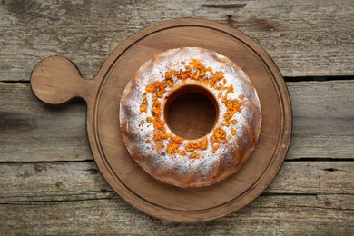 Photo of Homemade yogurt cake with tangerines and powdered sugar on wooden table, top view