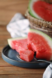 Photo of Fresh juicy watermelon and spoon on wooden table, closeup