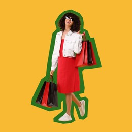 Happy woman with shopping bags on orange background