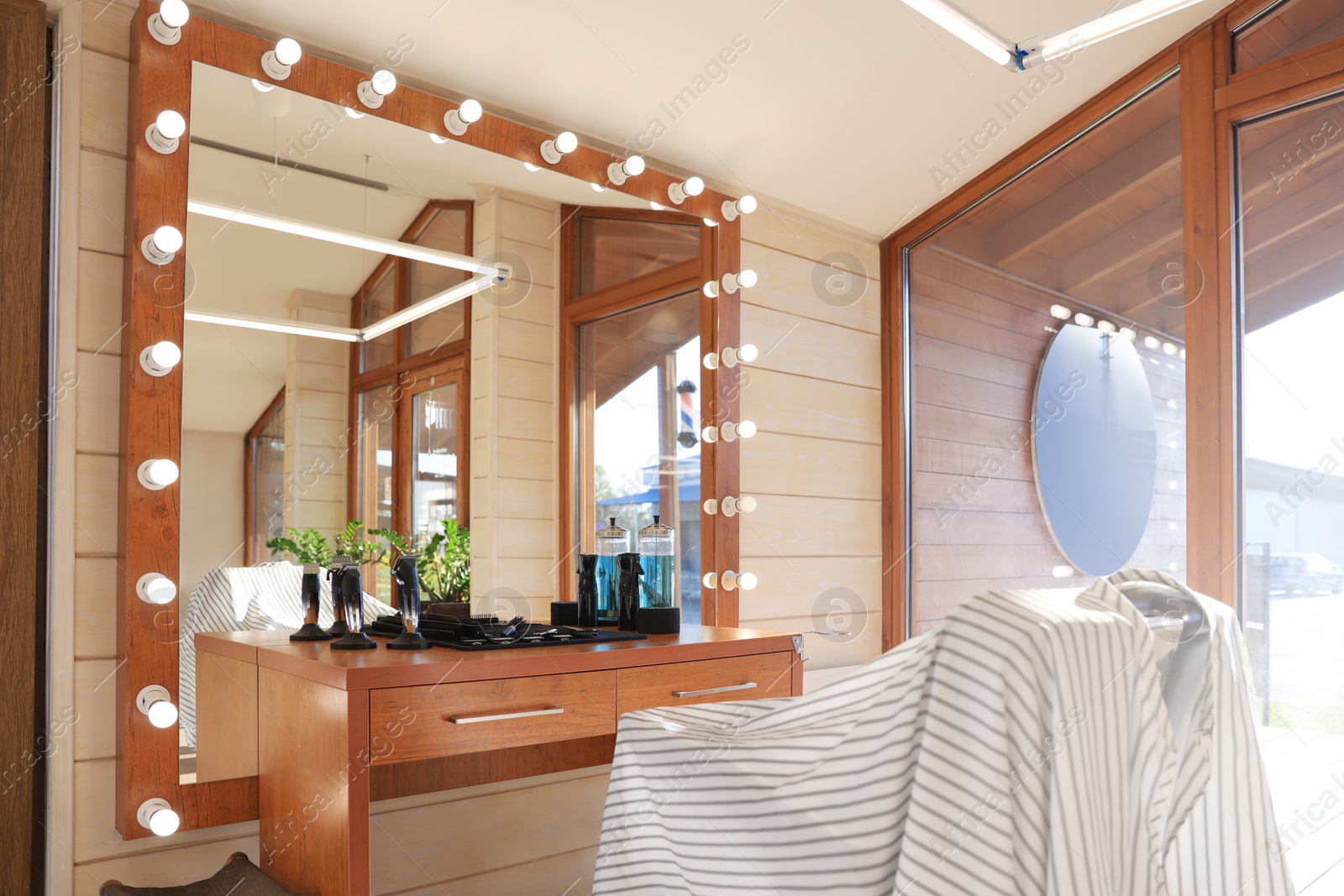 Photo of Stylish hairdresser's workplace with professional armchair and large mirror in barbershop