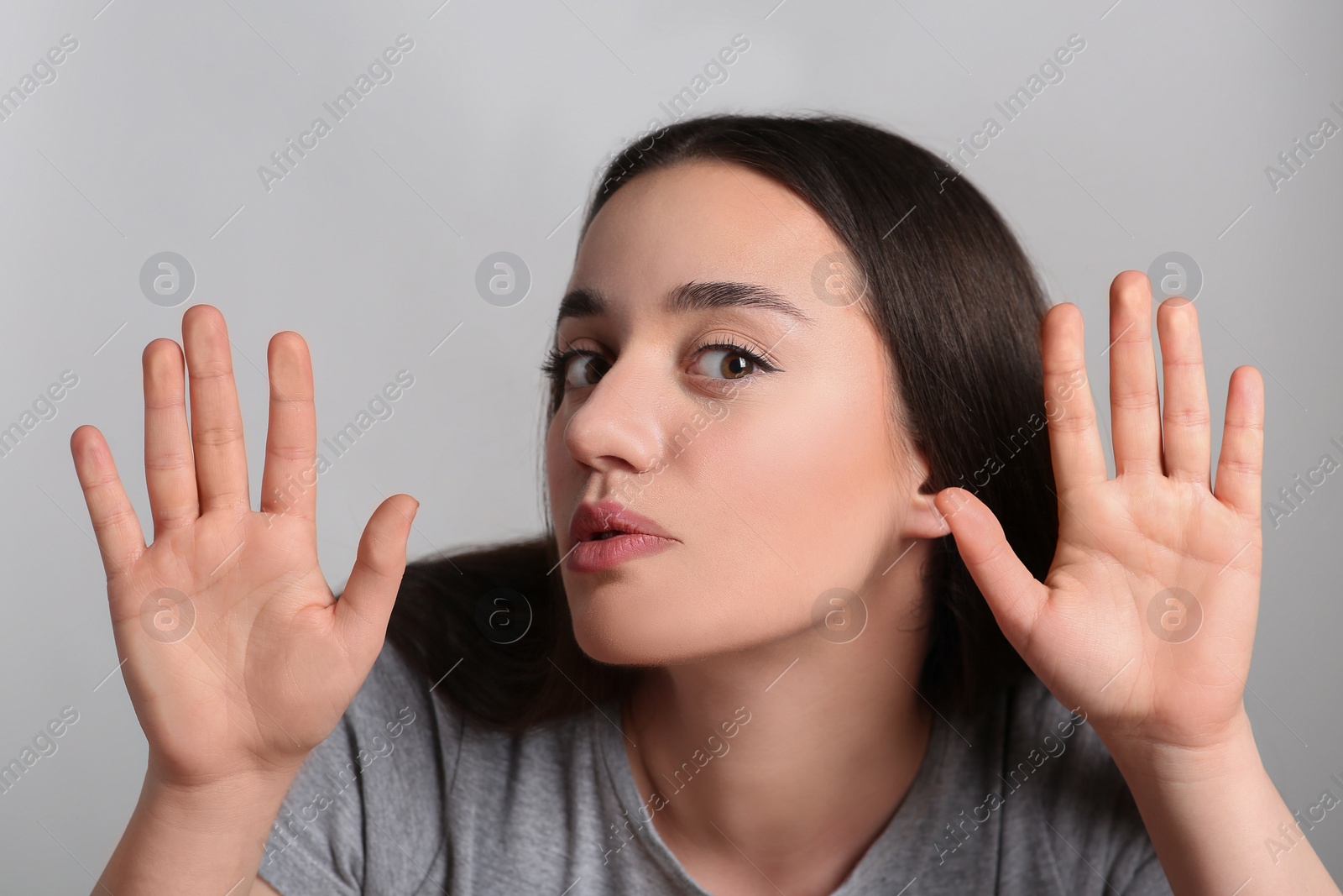 Photo of Young woman stuck to transparent screen. Internet addiction