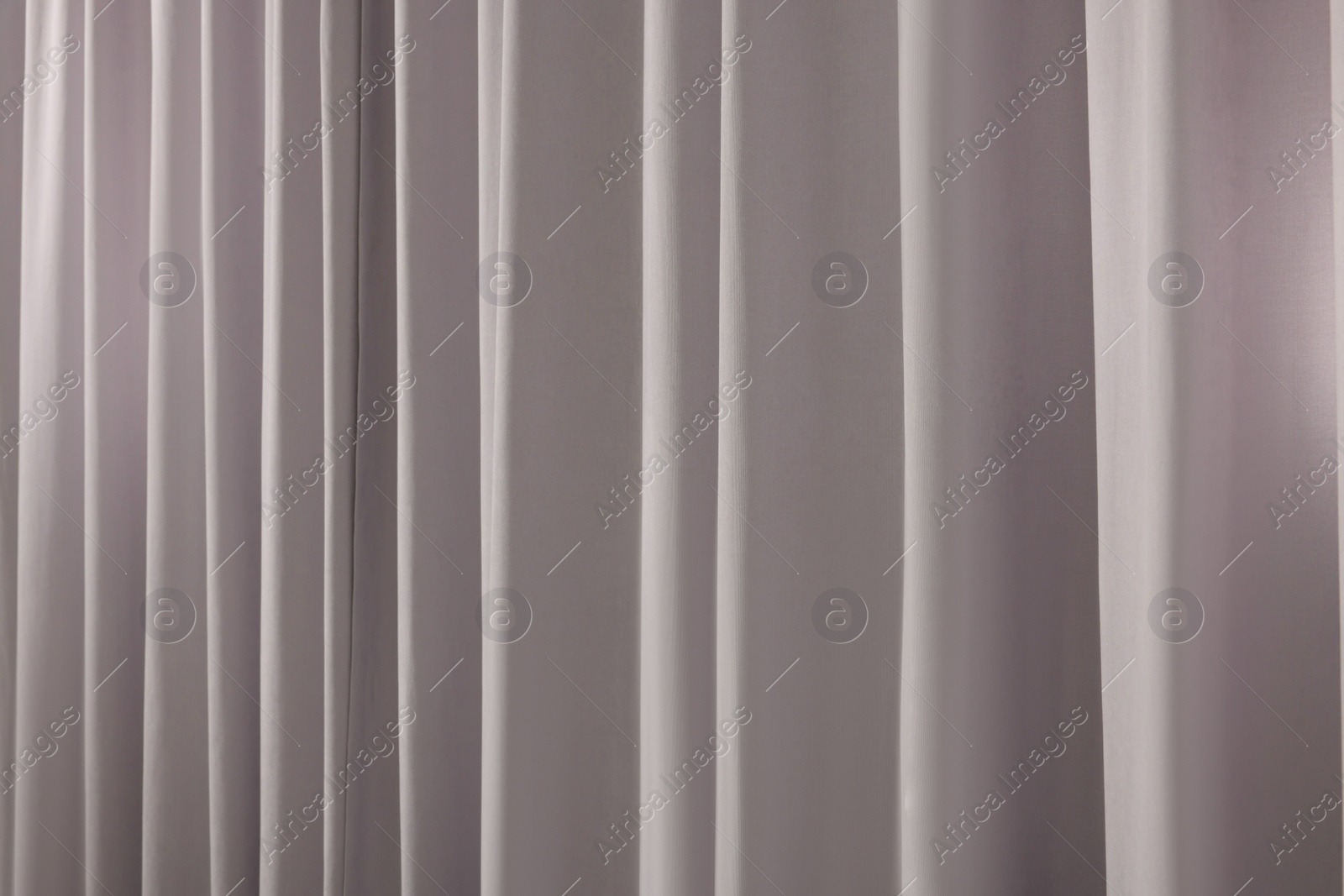 Photo of Beautiful light grey window curtains as background, closeup