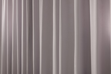 Beautiful light grey window curtains as background, closeup