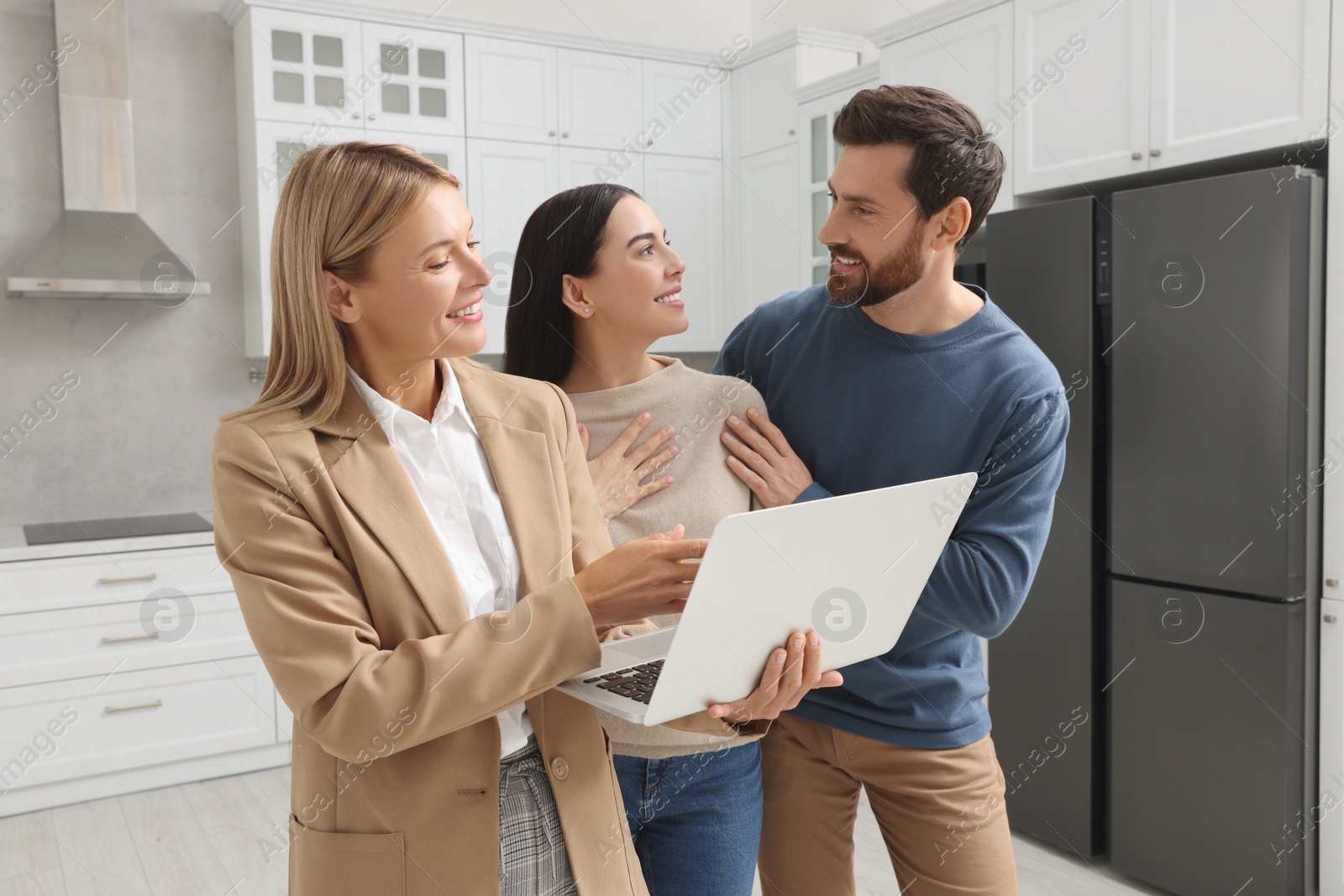 Photo of Real estate agent working with couple in new apartment