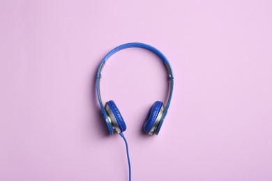 Photo of Stylish headphones on color background, top view