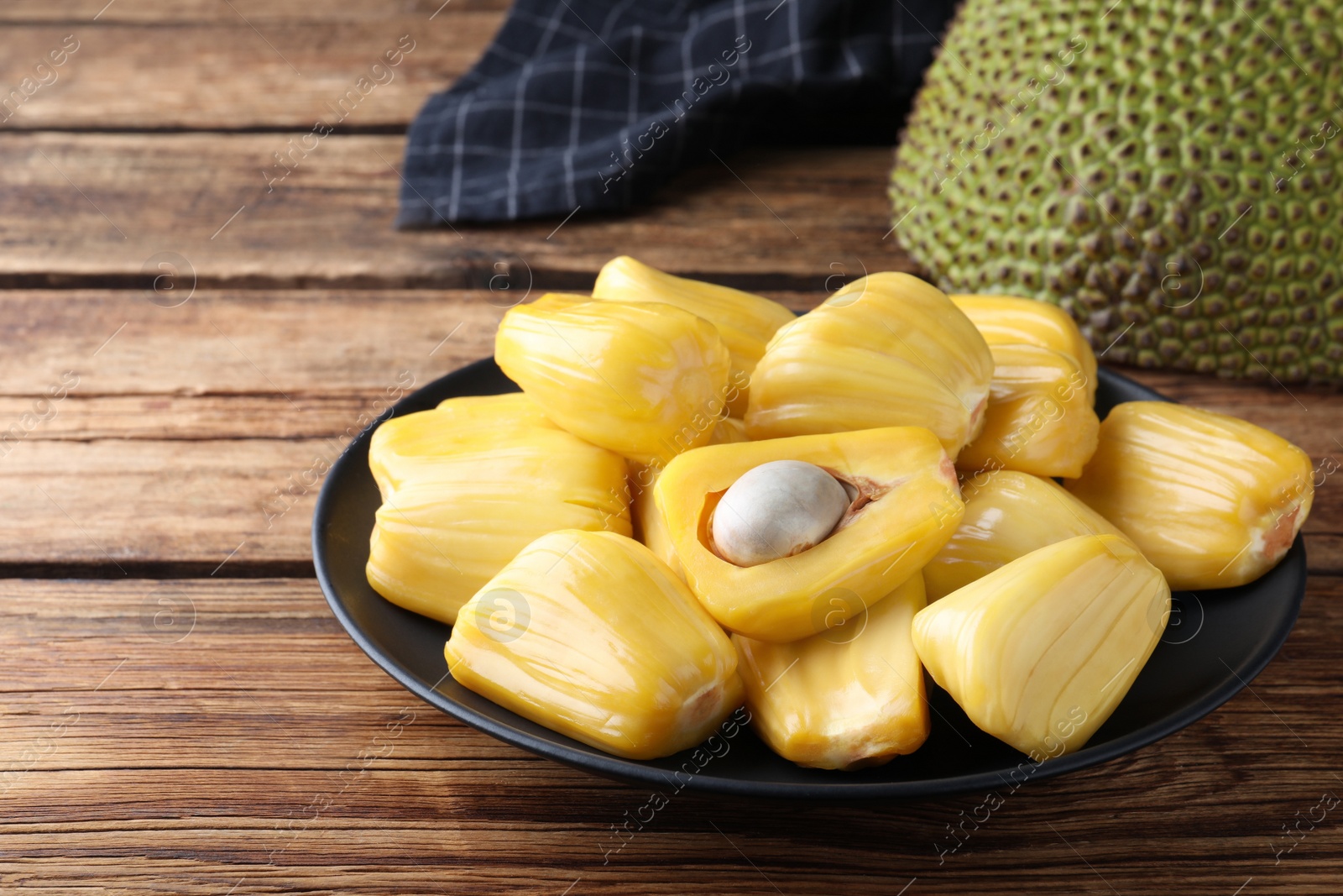 Photo of Fresh exotic jackfruit bulbs on wooden table