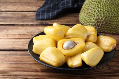 Fresh exotic jackfruit bulbs on wooden table