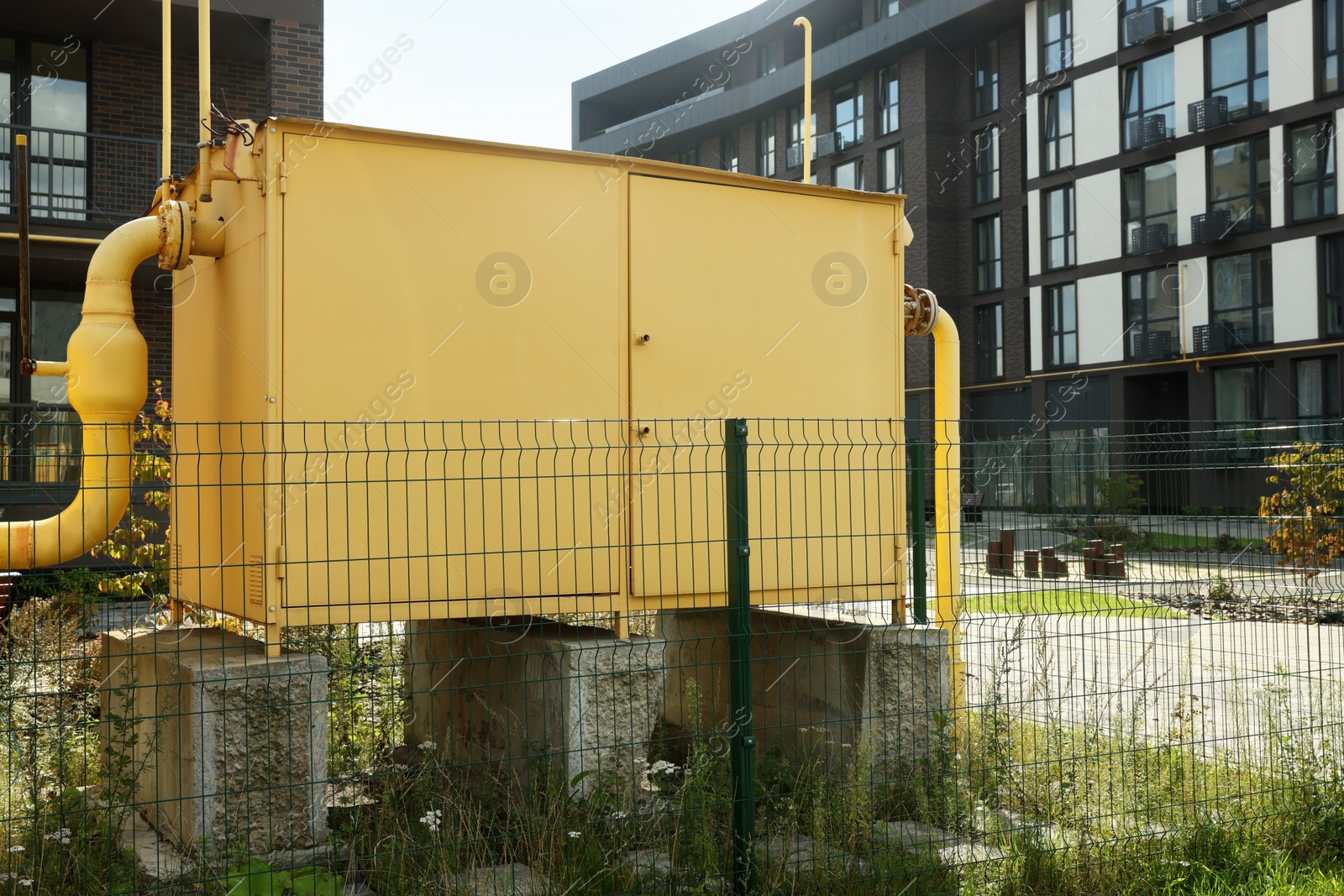 Photo of Big yellow gas distribution cabinet in residential area outdoors