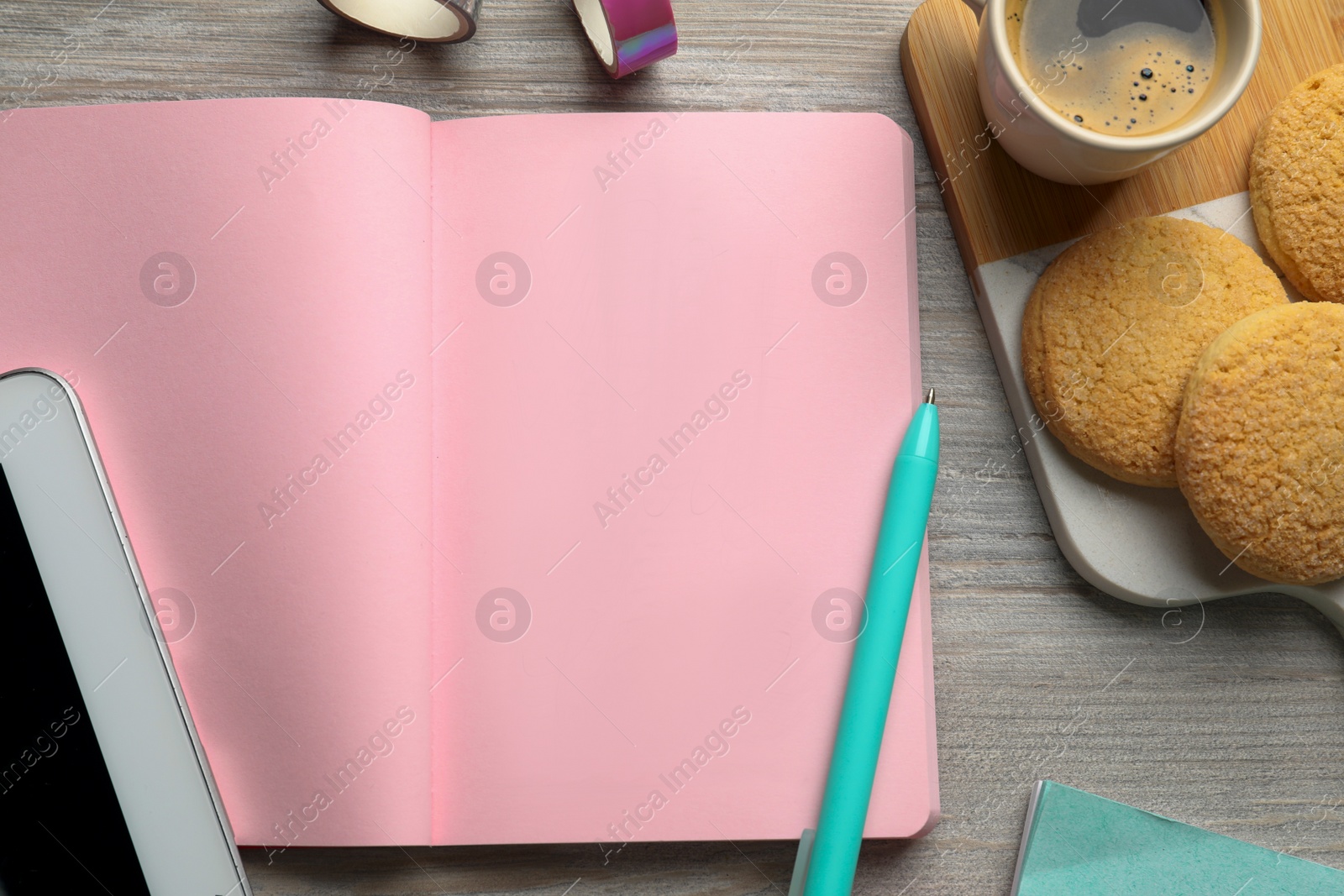 Photo of Open notebook, pen, coffee and cookies on wooden table, flat lay