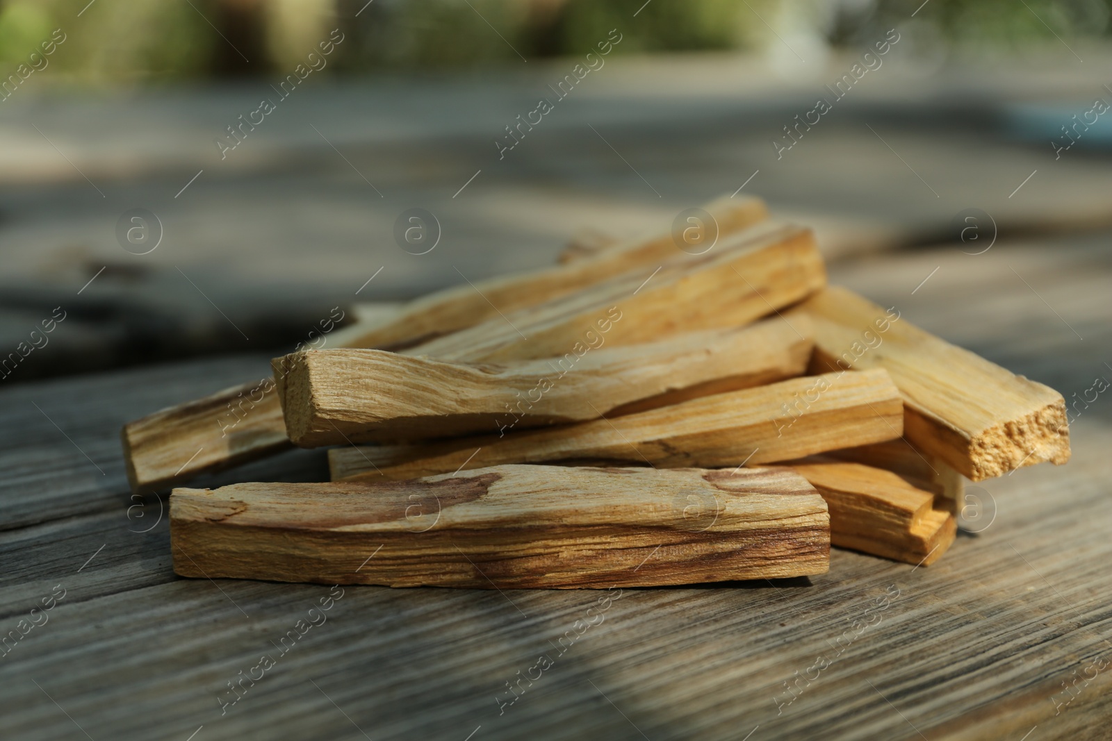 Photo of Palo santo sticks on wooden table outdoors