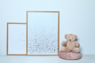 Photo of Adorable teddy bear and pictures on white background. Child room interior decor
