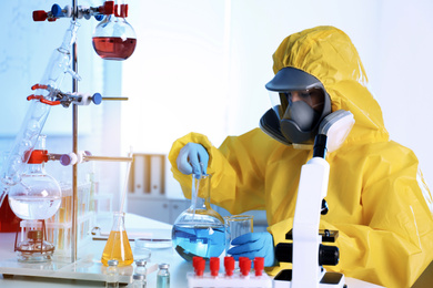 Scientist in chemical protective suit working at laboratory. Virus research