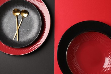 Stylish table setting with plates and spoons on color background, top view