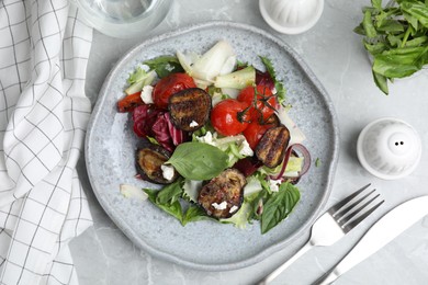 Photo of Delicious salad with roasted eggplant, basil and cheese served on grey marble table, flat lay