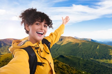 Image of Beautiful young woman taking selfie in mountains