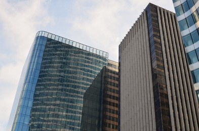 Exterior of different modern skyscrapers against blue sky, low angle view