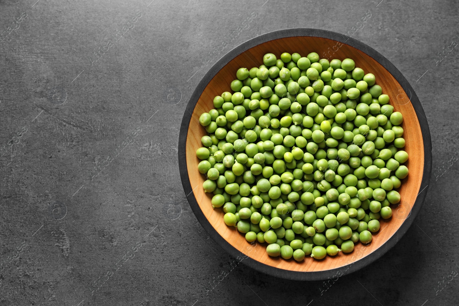 Photo of Plate with green peas on grey background, top view