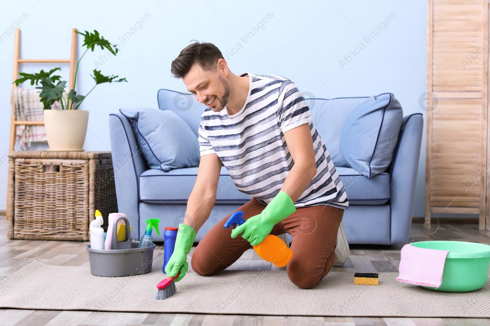 Photo of Mature man cleaning carpet at home