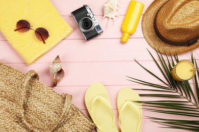 Frame of beach objects on pink wooden background, flat lay. Space for text