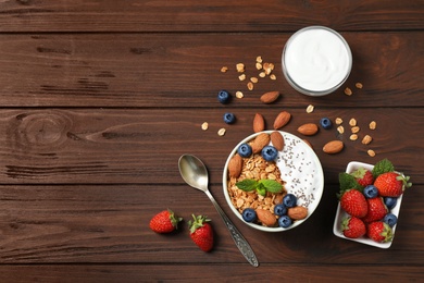Healthy homemade granola with yogurt on wooden table, flat lay. Space for text