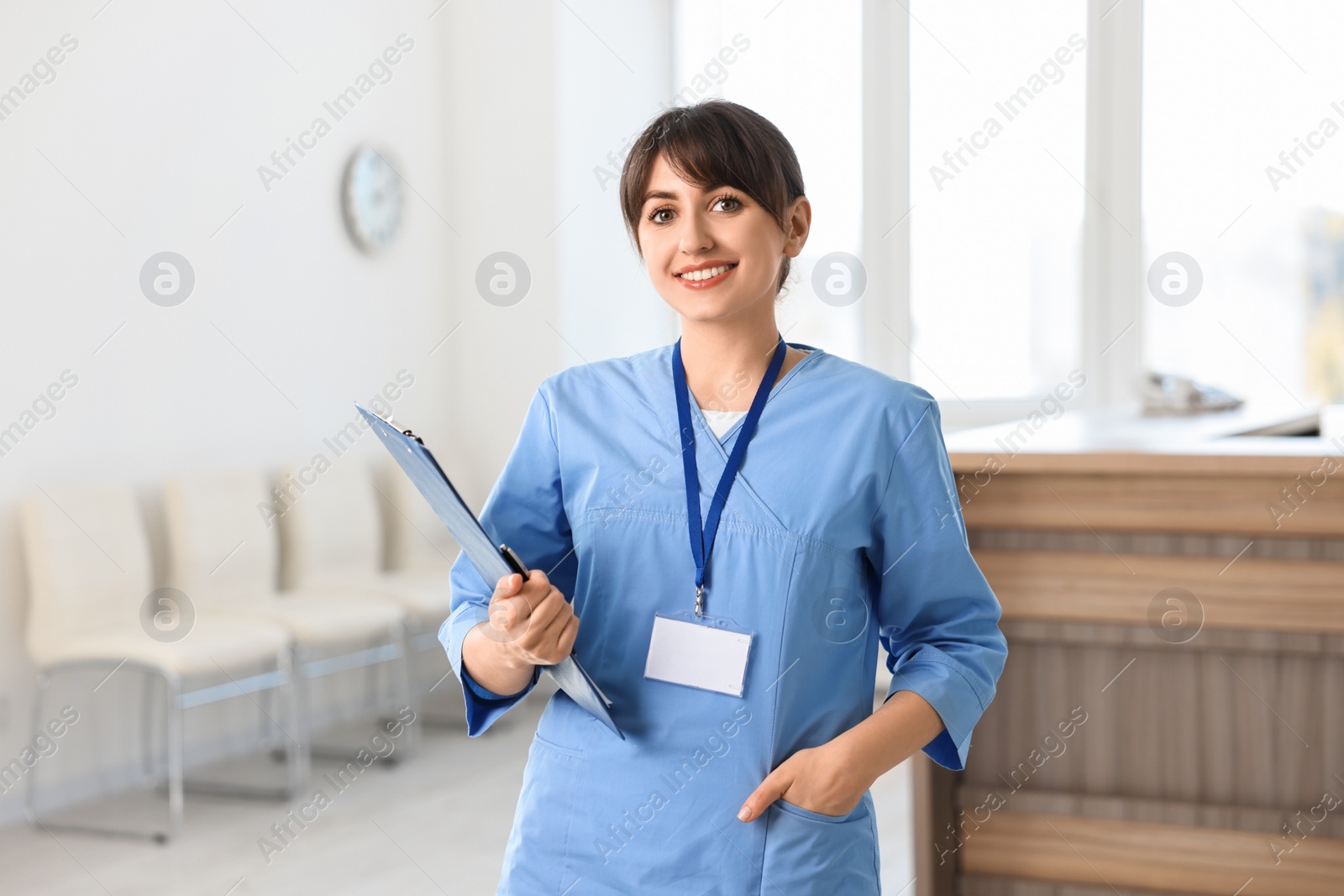 Photo of Portrait of smiling medical assistant with clipboard in hospital