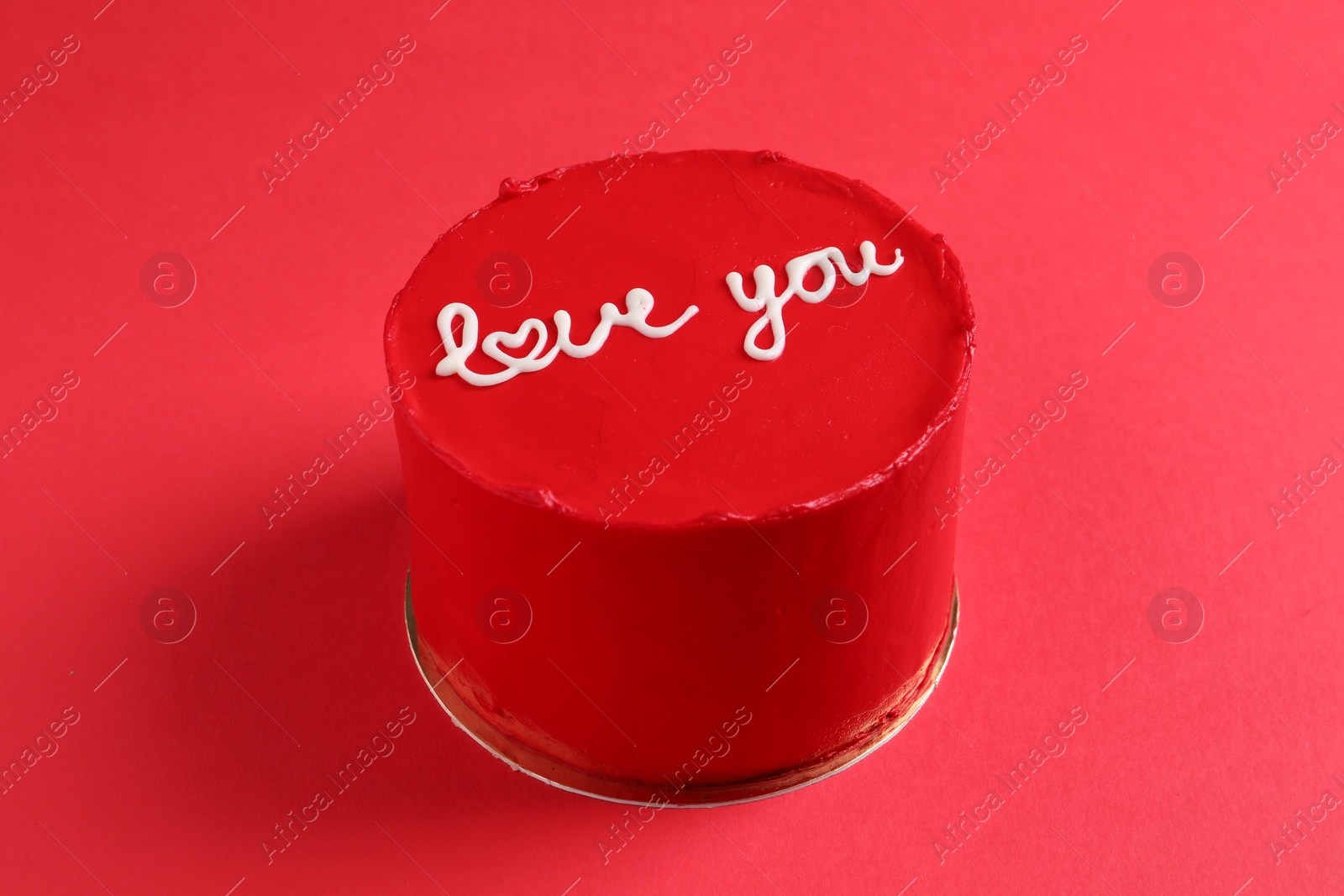 Photo of Bento cake with text Love You on red table. St. Valentine's day surprise