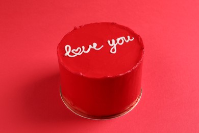 Photo of Bento cake with text Love You on red table. St. Valentine's day surprise